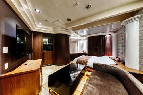 a bedroom with a bed and a desk in a room at HOTEL ARTIA DINOSAUR MACHIDA -Adult Only in Kami-seya