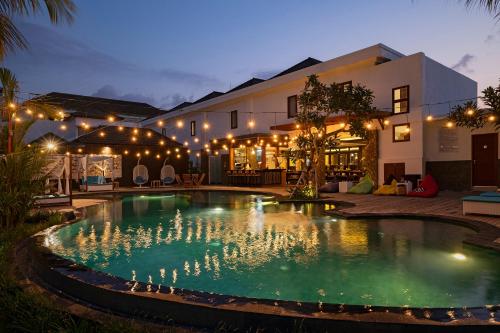 a swimming pool in front of a house at night at The Sakaye Villas & Spa in Legian