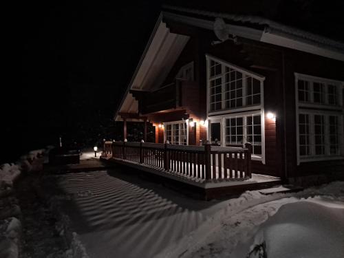 a house with a porch in the snow at night at Tahko Hills in Tahkovuori