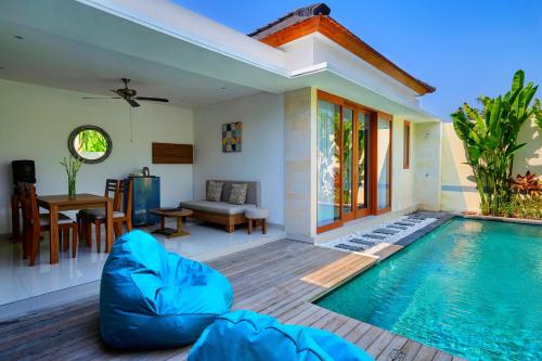 a villa with a swimming pool and a house at The Sakaye Villas & Spa in Legian