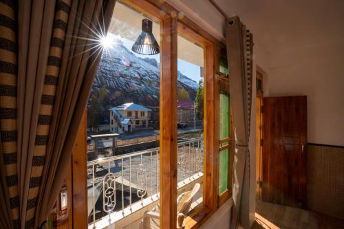a window in a room with a view of a mountain at Zostel Sissu in Sissu