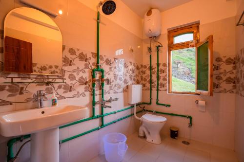 ein Badezimmer mit Waschbecken und Toilette in der Unterkunft Zostel Sissu in Sissu