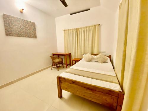 a bedroom with a bed and a desk at Tattwamasi Ayuryoga with Breakfast and Yoga in Varkala