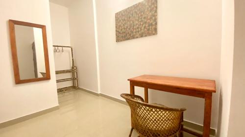 a table and chair in a room with a mirror at Tattwamasi Ayuryoga with Breakfast and Yoga in Varkala