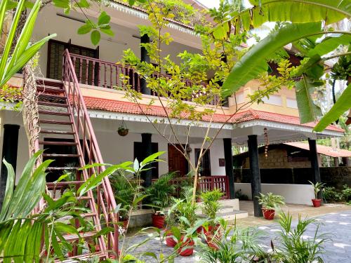 a house with a staircase and plants in front of it at Tattwamasi Ayuryoga with Breakfast and Yoga in Varkala