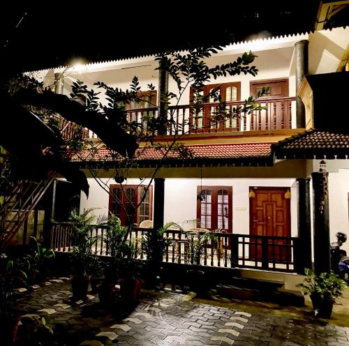 a large white house with a balcony at Tattwamasi Ayuryoga with Breakfast and Yoga in Varkala