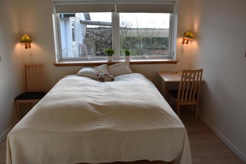a bedroom with a white bed and a window at Henne Strand Ferie Accommodation in Hennebjerg