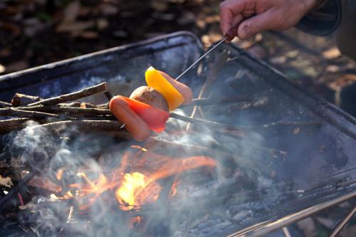 a person is cooking food on a grill at Hutte Lied in Komoro
