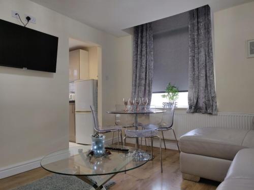 uma sala de estar com uma mesa de vidro e um sofá em Marmaduke Apartments - Entire Apartment Close to City Centre em Liverpool