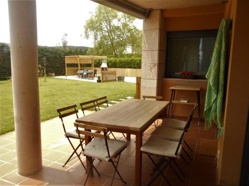 een houten tafel en stoelen op een patio bij CASA OIHANA in El Rasillo