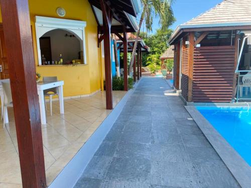 a pathway next to a house with a swimming pool at Bungalow idyllique à Vieux-Habitants avec vue sur la mer in Vieux-Habitants