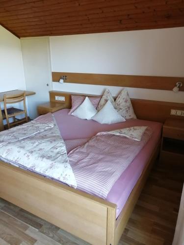 a bedroom with a large bed with a wooden headboard at Haus Ebner Eppan an der Weinstraße St Pauls in Appiano sulla Strada del Vino