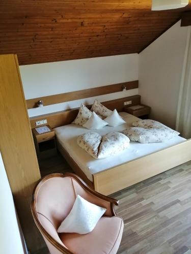 a bedroom with two beds and a chair and a chair at Haus Ebner Eppan an der Weinstraße St Pauls in Appiano sulla Strada del Vino