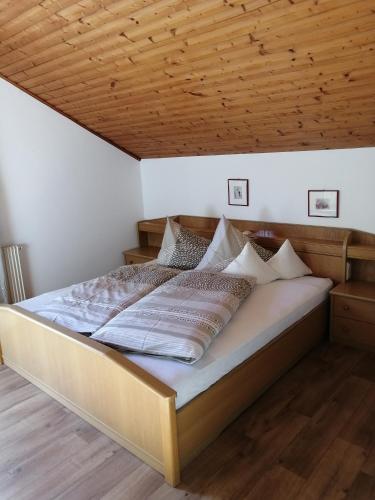 a bed in a room with a wooden ceiling at Haus Ebner Eppan an der Weinstraße St Pauls in Appiano sulla Strada del Vino
