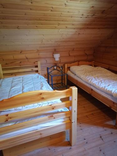 - 2 lits dans une cabine aux murs en bois dans l'établissement Spacieux Chalet, à Les Chapelles