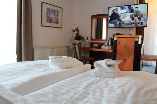 a hotel room with two beds and a tv at Hotel Residenz Bad Frankenhausen in Bad Frankenhausen
