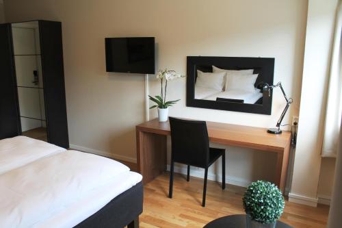 a bedroom with a desk with a bed and a mirror at Støren Hotel in Storen