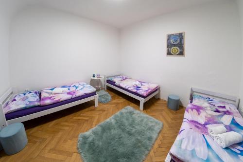 a room with two beds and a rug at Castle View Apartment in Prague