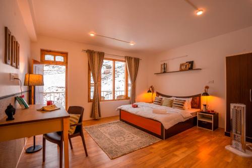 a bedroom with a bed and a desk and a desk at Zostel Sissu in Sissu