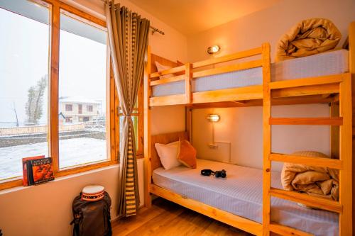 a bedroom with bunk beds and a window at Zostel Sissu in Sissu