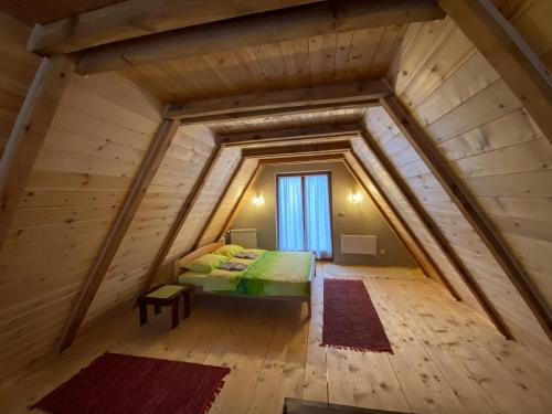 a room with a bed in the middle of a attic at Vikendica Stojanović in Mionica