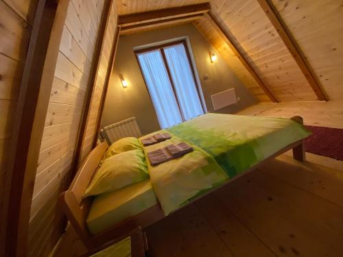 a bed in a small room with a window at Vikendica Stojanović in Mionica