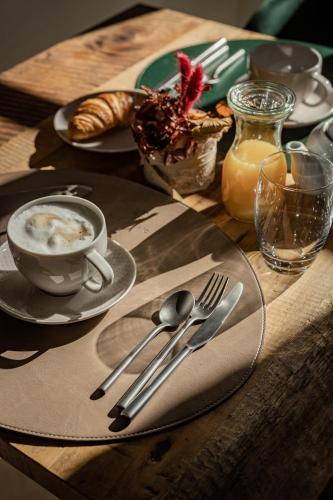 a table with a cup of coffee and a plate of food at Sce Quiríc in San Quirico dʼOrcia