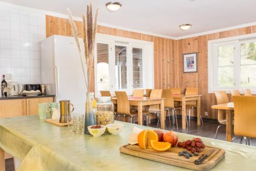 a kitchen with a table with a cutting board with fruit on it at Flåm Hostel in Flåm