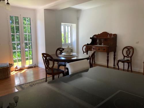 a living room with a table and chairs and a piano at Quintinha de Palmyra in Camacha