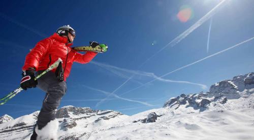 a man jumping in the air while holding a snowboard at Sarca Lodge Val Rendena in Dare