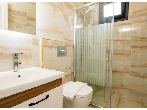 e bagno con servizi igienici, lavandino e doccia. di Doganın Ruhu Hotel & Bungalow a Kaş