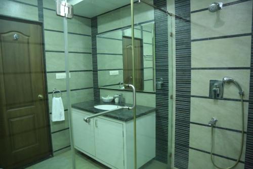 y baño con lavabo, ducha y espejo. en Swan Suites Madhapur, en Hyderabad