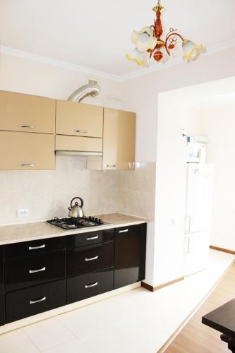 a kitchen with black cabinets and a white counter top at Центр міста однокімнатна новобудова in Lutsk
