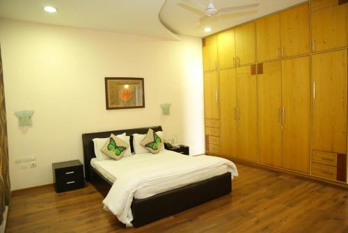 a bedroom with a large bed and wooden cabinets at Swan Suites Madhapur in Hyderabad