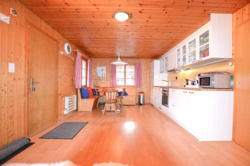 a large kitchen with wooden walls and a wooden floor at Chalet Castellani Apartment in Fiesch