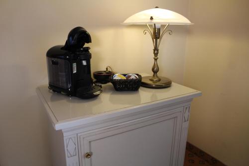 a table with a coffee maker and a lamp on it at Hotel Residenz Bad Frankenhausen in Bad Frankenhausen