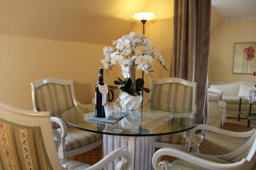 a table with a bottle of wine and flowers on it at Hotel Residenz Bad Frankenhausen in Bad Frankenhausen