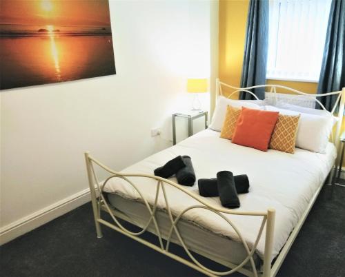 a bedroom with a white bed with colorful pillows at Modern comfy 2-Bedroom flat in St Helens in Saint Helens