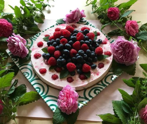 a cake with berries on it on a table with flowers at Martins Hotel in Schweinfurt