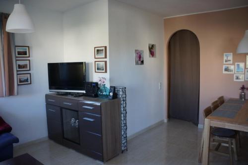 a living room with a flat screen tv and a table at Laila in Riumar