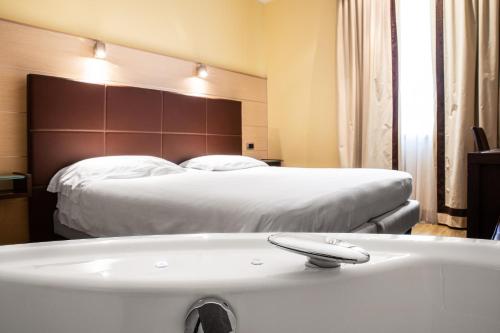 a bathroom with a bed and a bath tub at Hotel Master in Brescia