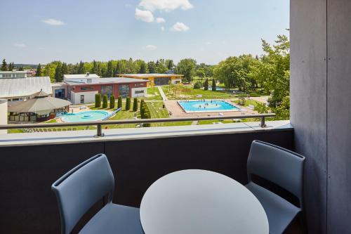 a room with chairs and a view of a pool at Thermal Hotel Balance Lenti in Lenti