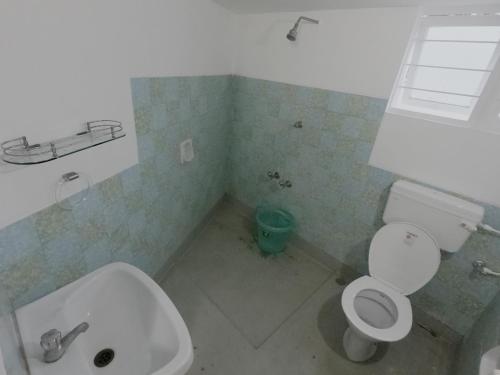 Un baño con un inodoro blanco y un lavabo. en LE SUNSHINE RESIDENCY, en Pondicherry
