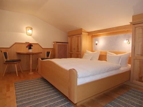 a bedroom with a large bed and a table at Gasthof Rehwinkl in Ramsau