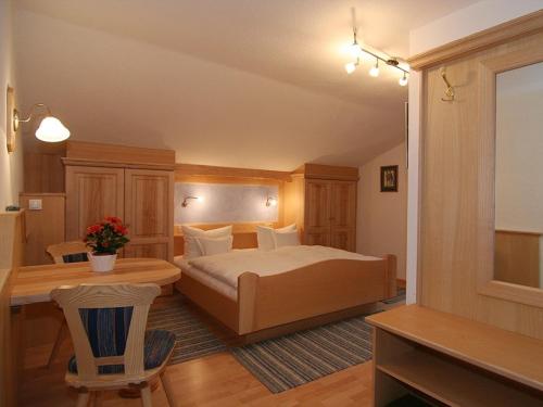 a bedroom with a bed and a desk and a table at Gasthof Rehwinkl in Ramsau