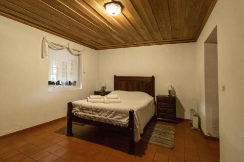 1 dormitorio con cama y techo de madera en Soajo Casa de Campo (PNPG), en Soajo