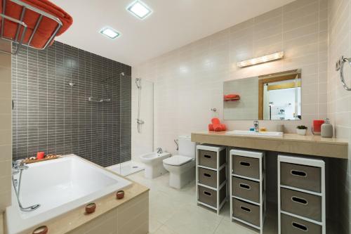 薩洛布雷的住宿－Exclusive Villa Golf，带浴缸、盥洗盆和卫生间的浴室