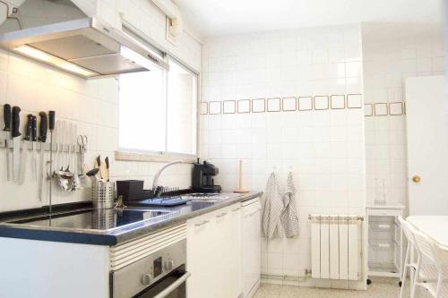 a white kitchen with a sink and a window at Apartamento AVENIDA DO MAR in A Coruña