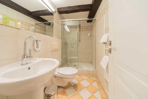 a bathroom with a sink and a toilet and a shower at Romantik Hotel Walhalla in Osnabrück