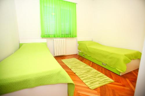 a room with two beds and a window at Apartments Nakir in Slatine